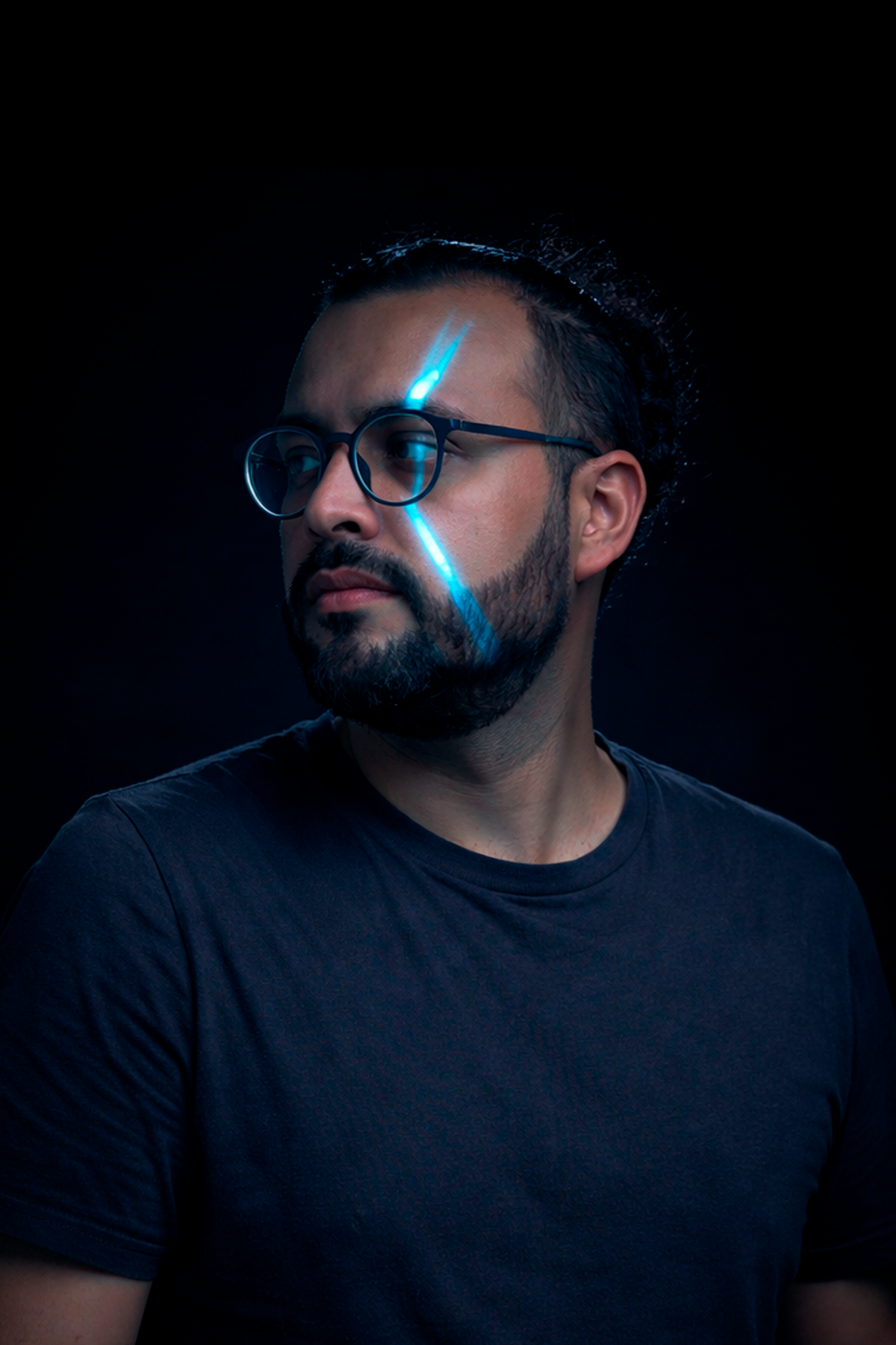Kev Bustos de perfil con destellos de luz azul.